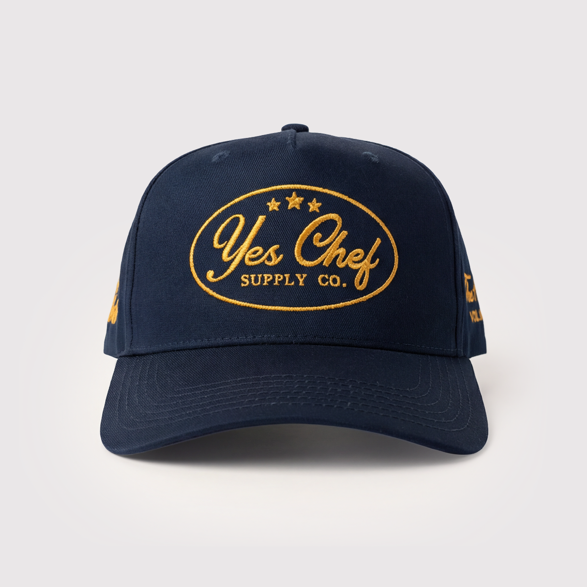 Navy blue cap with 'Yes Chef Supply Co.' logo on a light gray background